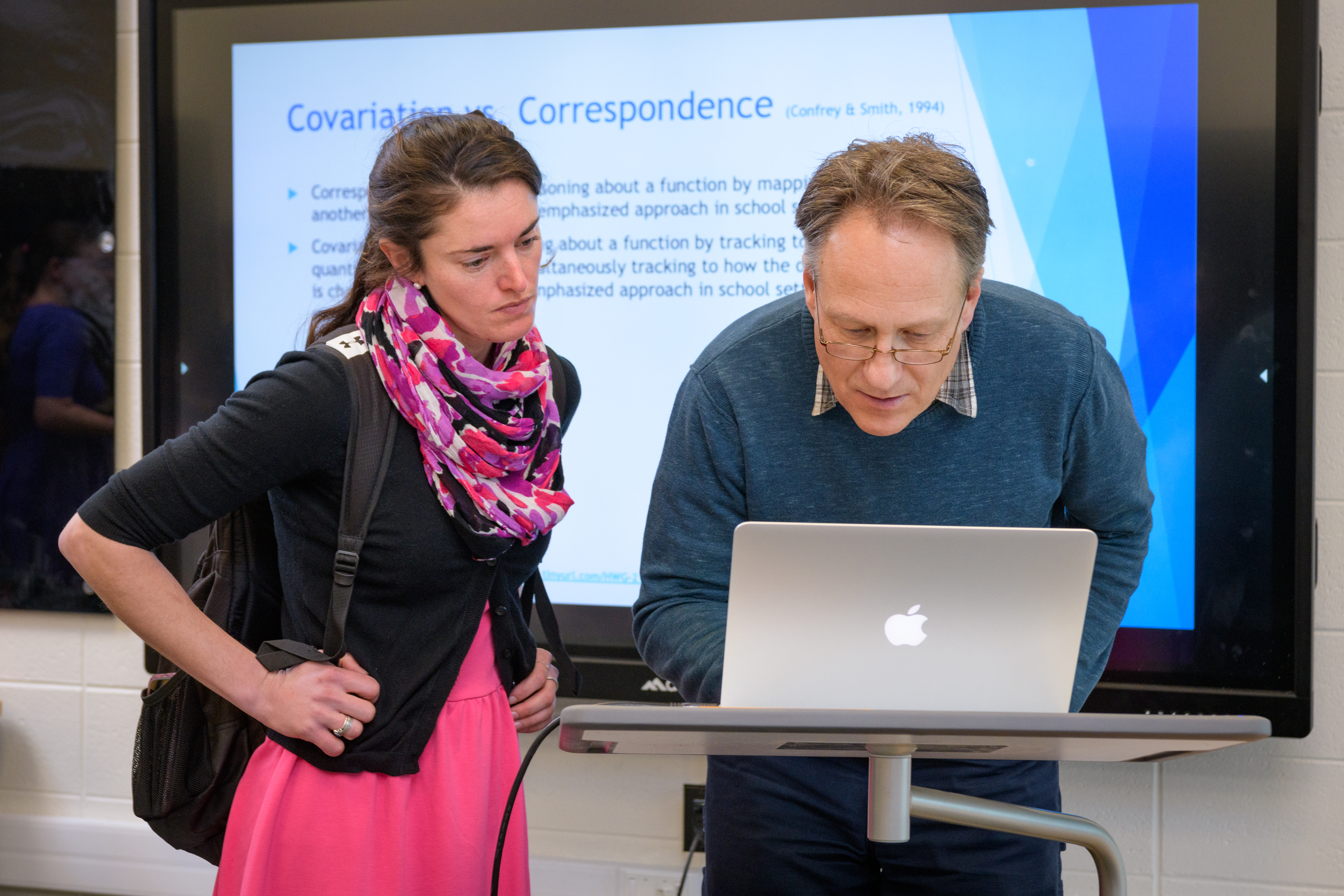 Two educators looking at laptop